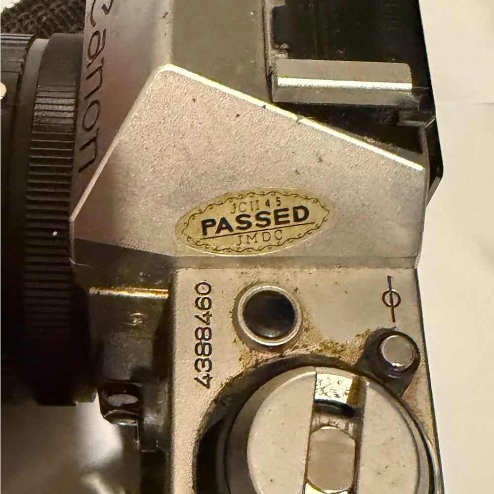 Canon silver and black SLR camera with black telephoto lens